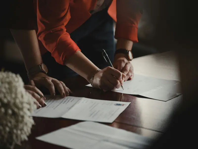 Firma de un documento sobre una mesa de madera