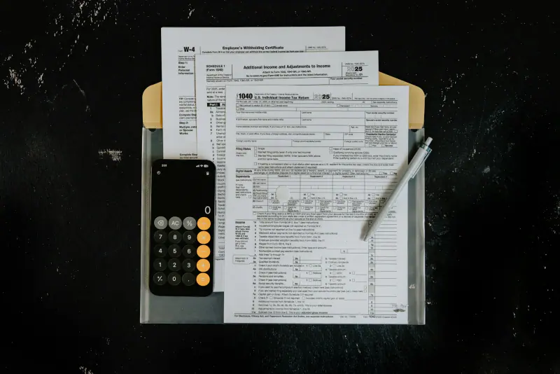 Formularios y una calculadora sobre una mesa oscura