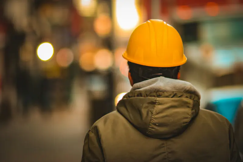 Trabajador con casco amarillo que averigua cuánto cobra un abogado laboral