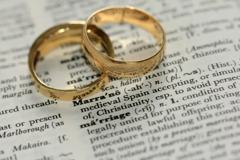 Dos anillos dorados sobre un papel, al calcular cuánto cuesta un divorcio en Colombia