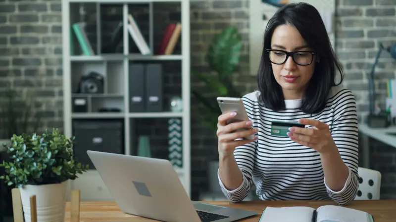 Mujer revisando en su celular el estado de su tarjeta de crédito