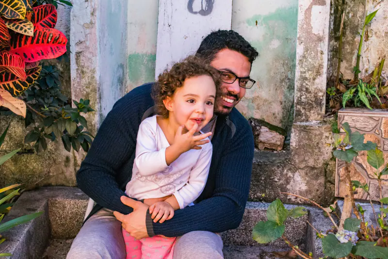 Padre abrazando a su hija pequeña en casa