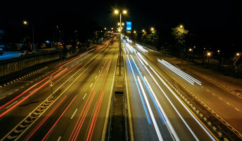 Autopista de noche con las luces de los carros en movimiento